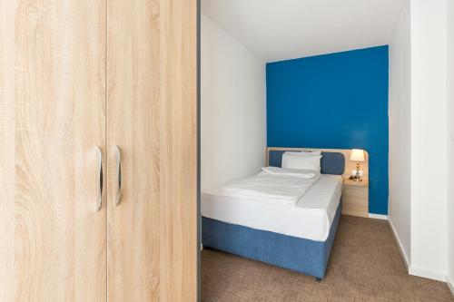 a small bedroom with a bed and a cabinet at Premium Crown Suites in Belgrade