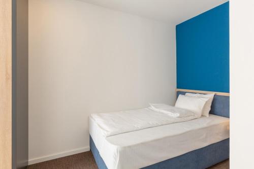 a bed in a room with a blue and white wall at Premium Crown Suites in Belgrade