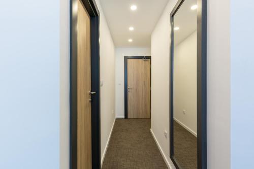 a hallway with a mirror and a door at Premium Crown Suites in Belgrade