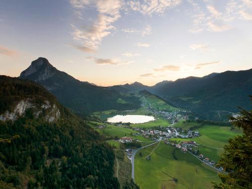 a valley in the mountains with a town and a lake at Aparthotel Buchauer-Tirol in Thiersee