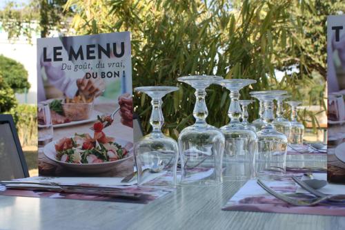 a table with wine glasses and a bowl of salad at Campanile Le Mans - Arnage in Arnage