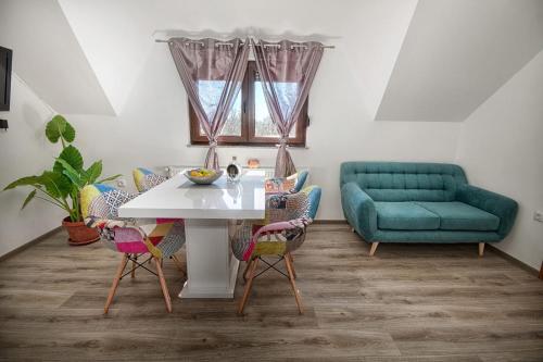 uma sala de estar com uma mesa e um sofá verde em Apartments Escape em Drežnik Grad