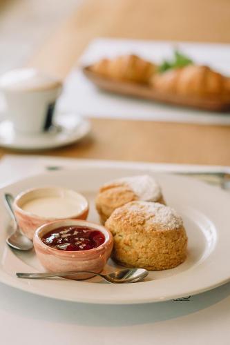 Un plato de comida con galletas y mermelada en una mesa. en Charco Hotel, en Colonia del Sacramento