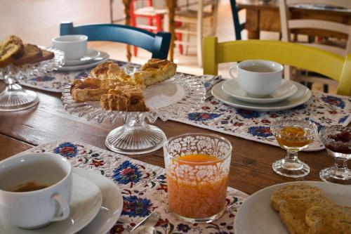 uma mesa de madeira com pratos e chávenas de café e pastelaria em Borgo Dei Conti Della Torre em Morsano al Tagliamento