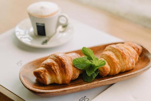 Un plato de croissants sobre una mesa con una taza de café. en Charco Hotel, en Colonia del Sacramento