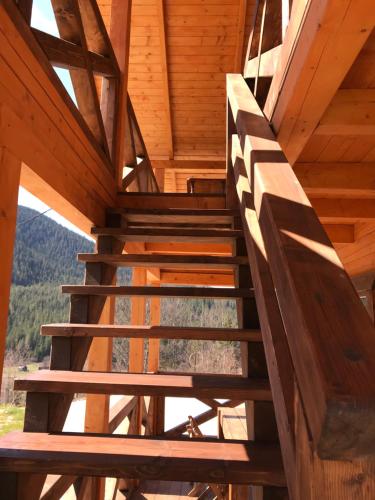 a staircase in a cabin with wooden ceilings and windows at Kozichky Guest House in Tatariv