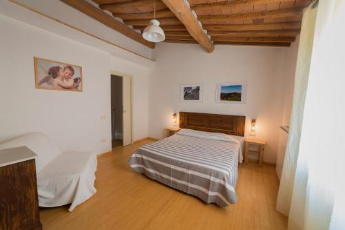 ein Schlafzimmer mit einem Bett und einer Holzdecke in der Unterkunft Agriturismo Podere Carducci in Castagneto Carducci