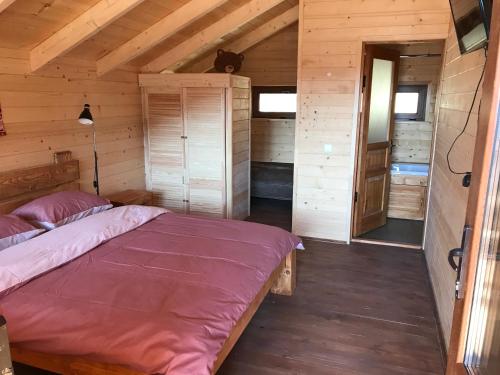 a bedroom with a bed in a wooden cabin at Kozichky Guest House in Tatariv