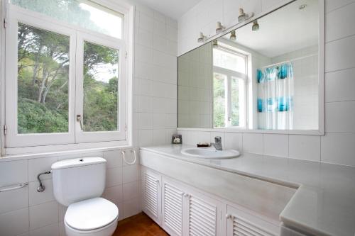 a bathroom with a toilet and a sink and a mirror at Casa Malva Sa Tuna in Begur