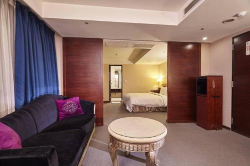 a living room with a couch and a bed at Family Hotel Taipei in Zhonghe