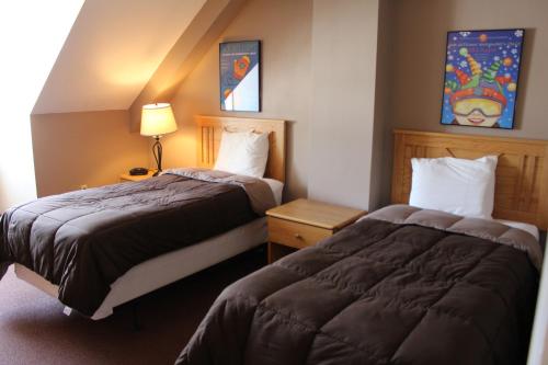 a hotel room with two beds and a lamp at Town Square Condominiums in Waterville Valley