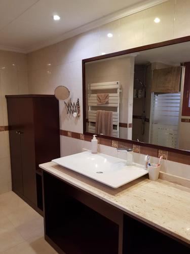 a bathroom with a sink and a large mirror at Iberflat Villa Tramontana in Benicàssim