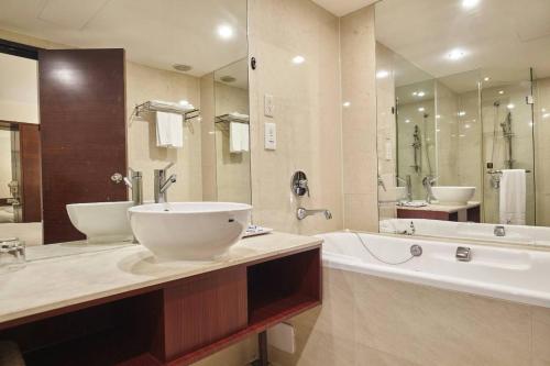 La grande salle de bains est pourvue d'une baignoire, d'un lavabo et d'une baignoire. dans l'établissement Family Hotel Taipei, à Zhonghe
