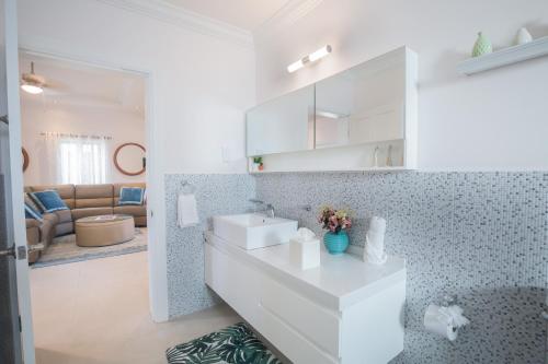 a white bathroom with a sink and a living room at Bay Gardens Beach Resort & Spa in Gros Islet
