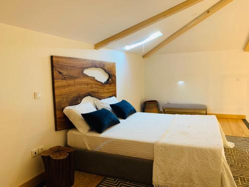 a bedroom with a large bed with blue pillows at L'atelier Apartments (Pintura) in Guimarães