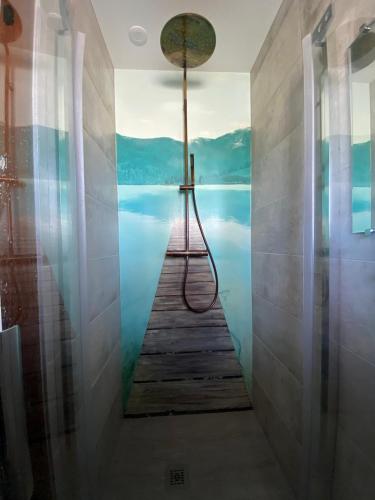 La salle de bains est pourvue d'une douche et offre une vue sur l'eau. dans l'établissement Le Clos de Mon Père, à Le Pont-de-Beauvoisin