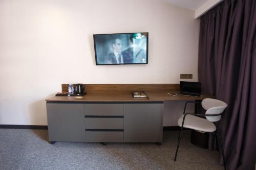 a desk with a laptop on top of it next to a curtain at Kulikovskiy hotel in Kharkiv
