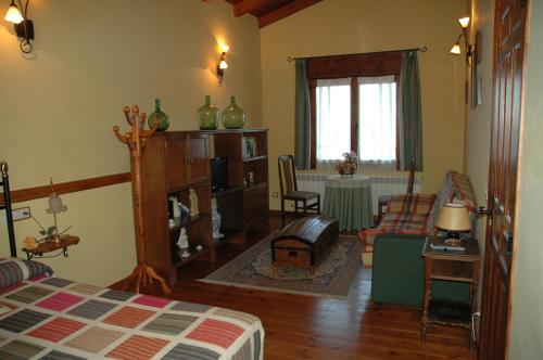 a bedroom with a bed and a living room at Casa Rural El Colorao in Sotés