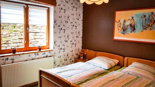 a bedroom with two beds and a window at Ferienwohnung Reuscher, Trier-Newel in Newel