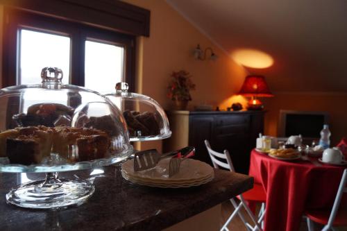 una mesa con un pastel en un plato de vidrio. en B&B Il Fruscio, en Mormanno