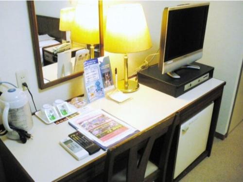 Sky Heart Hotel Kawasaki / Vacation STAY 80810 في كاواساكي: مكتب فيه كمبيوتر وشاشة عليه