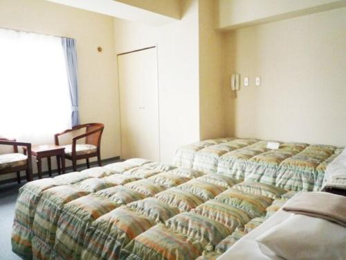 a bedroom with three beds in a room at Sky Heart Hotel Kawasaki / Vacation STAY 80807 in Kawasaki
