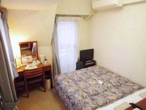 1 dormitorio con 1 cama y escritorio con ordenador en Sky Heart Hotel Kawasaki / Vacation STAY 80809, en Kawasaki