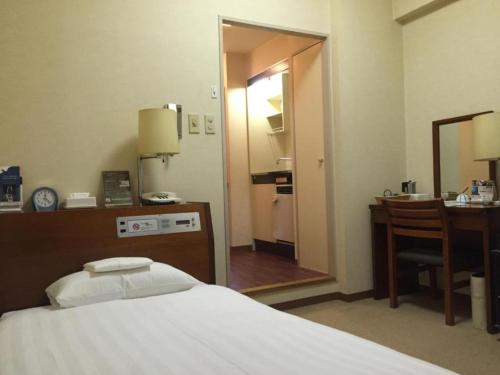 a bedroom with a bed and a desk and a mirror at Sky Heart Hotel Kawasaki / Vacation STAY 80788 in Kawasaki