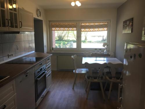 a kitchen with a table and chairs and a dining room at Huck’s Ferienhäuser in Borstel