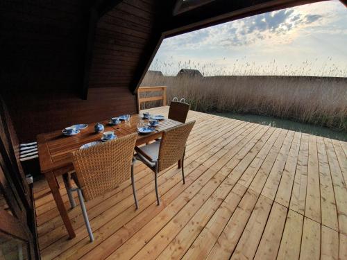 a wooden table and chairs on a wooden deck at Mountains and Lakes - Romantika 5 Beach Bungalow in Rust