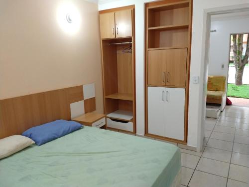 a bedroom with a bed and some cabinets and a door at diRoma Fiori - Apartamentos JN in Caldas Novas