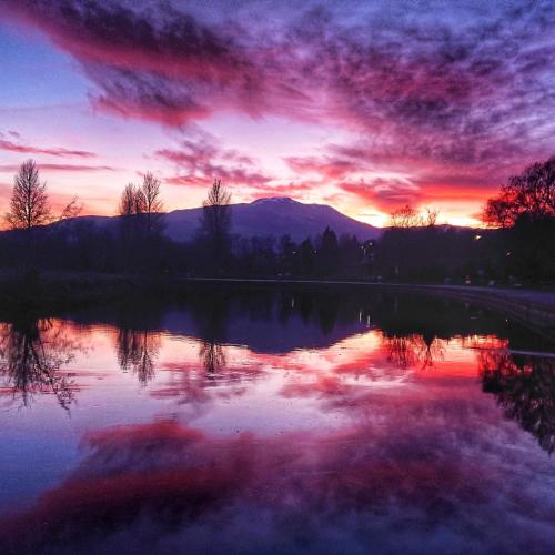 a sunset over a lake with a mountain in the background at Riverbank in Callander