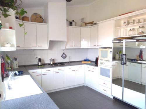 a white kitchen with white cabinets and a sink at Vivenda Cinco Reis in Angra do Heroísmo
