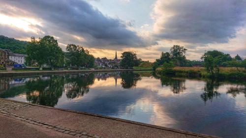 a river with trees and clouds in the sky at Riverbank in Callander