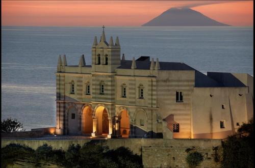 an old castle with a mountain in the background at ele&gio accomodation in Tropea