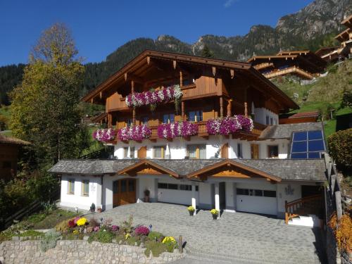 a large house with flowers on the balcony at Haus Kristall in Alpbach
