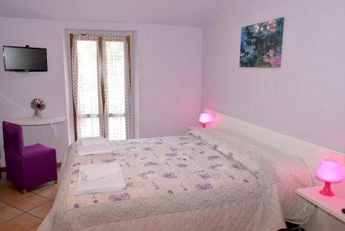a bedroom with a bed with pink lamps and a tv at Camere Paolo in Assisi