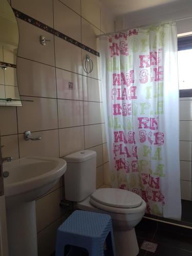 a bathroom with a toilet and a sink and a shower curtain at Villa Orestis in Stoupa