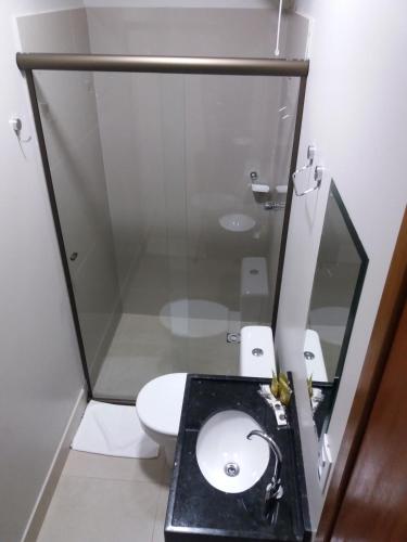 a bathroom with a toilet and a glass shower at Sleep Hotel in Toledo