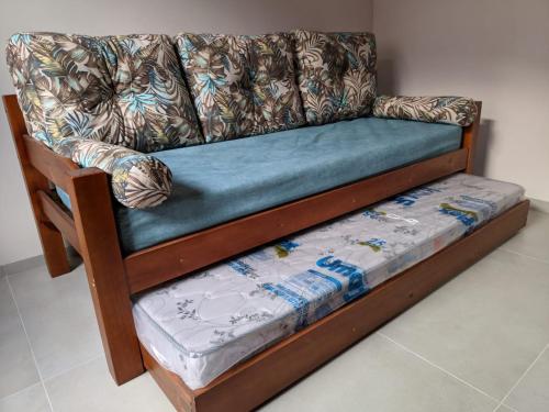 a couch sitting in a living room with a blue at Ubatuba Centro - Casa terreo completa in Ubatuba