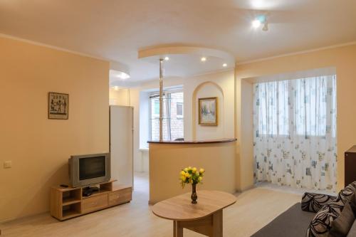 a living room with a tv and a vase of flowers on a table at 112 вулиця Велика Васильківська in Kyiv