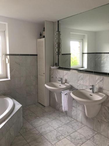 a bathroom with two sinks and a mirror at Rüsgen Ferienwohnung in Schwalmtal