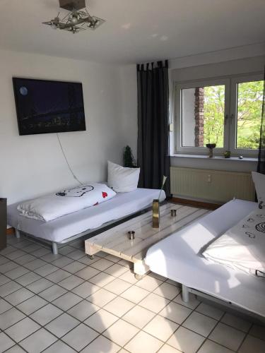 a room with two beds and a tv on the wall at Rüsgen Ferienwohnung in Schwalmtal