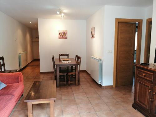 a living room with a table and a couch at Apartamentos Mobison in Salinas de Bielsa