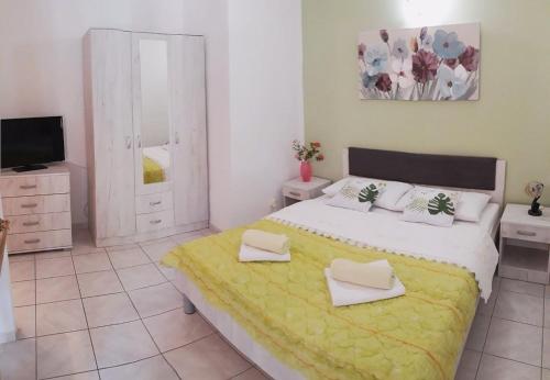 una camera da letto con un grande letto con una coperta gialla di Apartments Liza - 80 M from the sea a Korčula