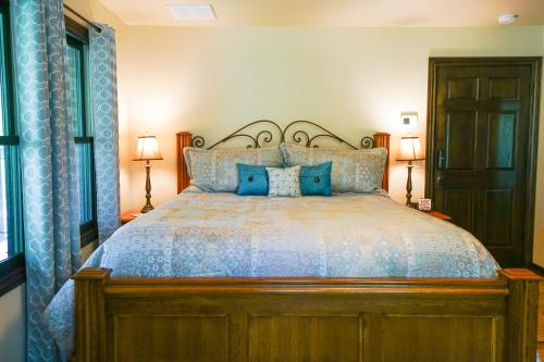 a bedroom with a large bed with blue pillows at Hidden Meadows Bed and Breakfast in Stillwater