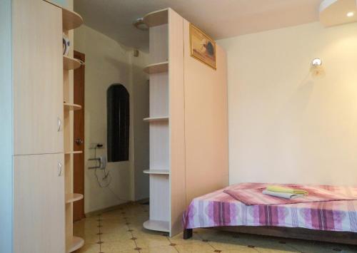 キーウにあるKhoroshaya Kvartira Goloseevskaya 3のベッド1台とクローゼットが備わる小さな客室です。