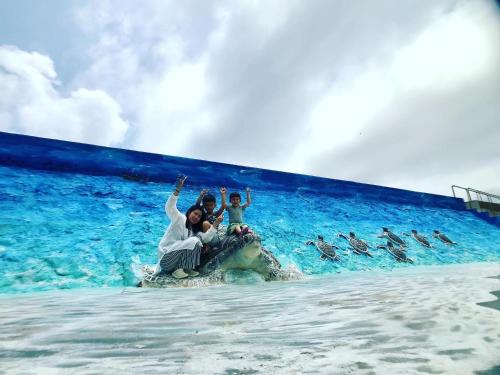 un grupo de personas montando en la espalda de un elefante en el agua en Le Nao Tourist Hostel, en Magong