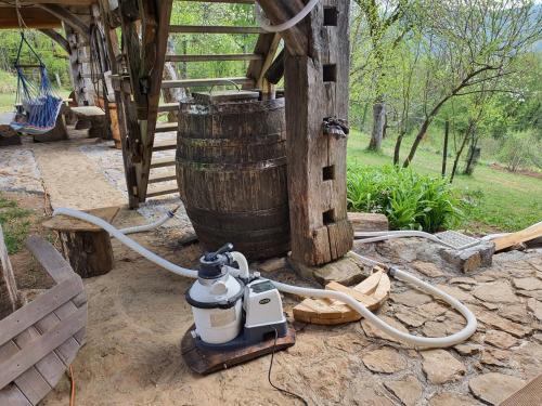 a water hydrant hooked up to a wooden barrel at Grey green and fun 4 YOU - 2 Cottages in Drganja Sela