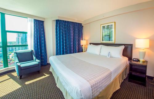 a hotel room with two beds and a television at Rosedale on Robson Suite Hotel in Vancouver